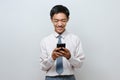 Portrait of happy Indonesian Student wearing senior high school uniform smiling looking at phone screen