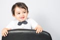 Happy joyful beautiful little boy on white background standing on chair