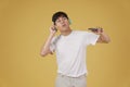 Portrait of happy joyful cheerful young asian man wearing headphones listening to music on smartphone and dancing isolated on Royalty Free Stock Photo