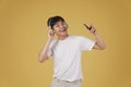 Portrait of happy joyful cheerful young asian man wearing headphones listening to music on smartphone and dancing isolated on Royalty Free Stock Photo