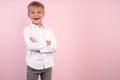 Portrait of happy joyful cute smiling little boy holding his hands crossed. studio portrait over pink background. Place wearing Royalty Free Stock Photo