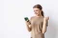 Portrait of a happy woman holding mobile phone and celebrating a win isolated over white background Royalty Free Stock Photo