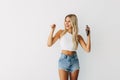 Portrait of a happy joyful girl holding mobile phone and celebrating a win over white background Royalty Free Stock Photo