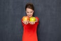 Portrait of happy joyful girl outstretching hands with apples to you Royalty Free Stock Photo