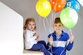 Portrait of happy kid boy and cute little toddler girl with bunch on colorful air balloons on birthday. Smiling happy Royalty Free Stock Photo