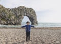 Portrait of happy kid boy smiling standing by the sea with blurry background, Chid playing in the Durdle Door beach in the weekend