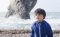 Portrait of happy kid boy smiling standing by the sea with blurry background, Chid playing in the Durdle Door beach in the weekend