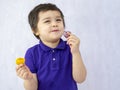 Portrait of happy kid eating macaroon on white background,Smile  Child enjoy his sweet snack ,Little boy holding food and looking Royalty Free Stock Photo