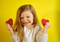 Portrait of happy kid girl holding a red heart for you, isolated on yellow background with copy space. Royalty Free Stock Photo