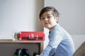 Portrait happy kid playing alone in living room, New normal life stlye Child relaxing at home on weekend. cute boy looking at Royalty Free Stock Photo