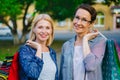 Portrait of happy ladies friends standing outdoors holding shopping bags smiling Royalty Free Stock Photo