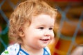 Portrait of a happy laughing baby child on sunny day. Close up positive kids on playground. Smiling infant, cute smile. Royalty Free Stock Photo