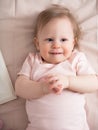 Portrait of a happy laughing baby, with a funny expression on his face. A small beautiful girl with blue eyes smiles cheerfully, Royalty Free Stock Photo