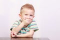 Portrait of happy laughing blond boy child kid at the table Royalty Free Stock Photo