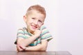 Portrait of happy laughing blond boy child kid at the table Royalty Free Stock Photo