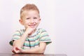 Portrait of happy laughing blond boy child kid at the table Royalty Free Stock Photo