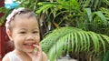 Portrait of happy laughing charming 3 years old Asian little girl smiling happily outdoors Royalty Free Stock Photo