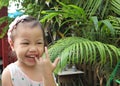 Portrait of happy laughing charming 3 years old Asian little girl smiling happily outdoors Royalty Free Stock Photo