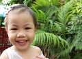 Portrait of happy laughing charming 3 years old Asian little girl smiling happily outdoors Royalty Free Stock Photo