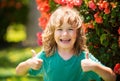 Portrait of a happy laughing child. Close up positive kids face, thumbs up sign.