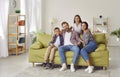 Happy laughing kids boy and girl having fun with their parents, sitting on sofa at home. Royalty Free Stock Photo