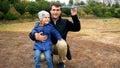 Portrait of happy laughing little boy with his father throwing toy airplane at park Royalty Free Stock Photo