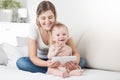 Portrait of happy laughing toddler boy and mother sitting on bed and using tablet computer Royalty Free Stock Photo