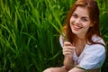 portrait of a happy, laughing woman sitting in tall grass in a field Royalty Free Stock Photo