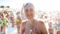 Portrait of happy laughing young woman in red bikini dancing on the sea beach. Girl having fun on sea beach soap foam