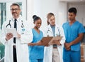 Portrait of a happy leader in a group of doctors and nurses planning surgery at the hospital. Medical team or healthcare Royalty Free Stock Photo