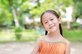 Portrait of happy little Asian child in green garden with looking at camera. Close up smiling kid girl in summer park Royalty Free Stock Photo