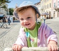 Portrait of a happy little baby girl in a denim hat and jacket laughing that expressing your emotions, walking on the Market Royalty Free Stock Photo