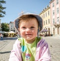 Portrait of a happy little baby girl in a denim hat and jacket laughing that expressing your emotions, walking on the Market