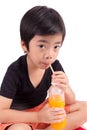 Portrait of happy little boy drinking orange juice Royalty Free Stock Photo