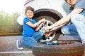 Little boy helping his father to change car wheel Royalty Free Stock Photo