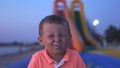 Portrait of happy little boy squinting with candy in mouth