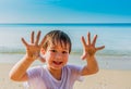 Portrait of happy little boy on summer beach with show sand on hands Royalty Free Stock Photo