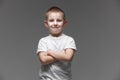 Portrait of happy little boy in white t-shirt smiling on gray background looking at camera in studio setting. Portrait of Royalty Free Stock Photo