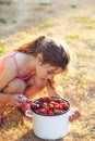 Portrait of Cute little gir playing and eating strawberries at summer day