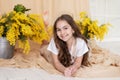 Portrait happy little girl with bouquet spring mimosa flowers. Branches mimosa yellow in vase. Mother's day. Royalty Free Stock Photo