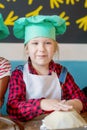 Portrait of a happy little girl in a chef`s cap and apron Royalty Free Stock Photo