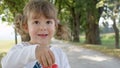 PORTRAIT: Happy little girl having fun blowing soap bubbles in the sunny park. Royalty Free Stock Photo