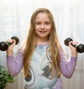 Portrait of happy little girl with dumbbells Royalty Free Stock Photo