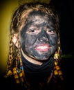 Portrait of a happy little girl with face painted with charcoal