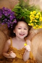 Portrait of a happy little girl lying on background with flowers and straw hat, summer and travel feeling concept