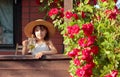 Portrait of little girl in straw hat with glass of herbal tea