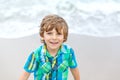 Portrait of happy little kid boy on the beach of ocean. Funny cute child making vacations and enjoying summer. Healthy Royalty Free Stock Photo