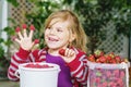 Portrait of happy little preschool girl eating healthy strawberries and raspberries. Smiling child with ripe berries Royalty Free Stock Photo