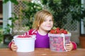 Portrait of happy little preschool girl eating healthy strawberries and raspberries. Smiling child with ripe berries Royalty Free Stock Photo