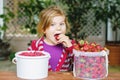 Portrait of happy little preschool girl eating healthy strawberries and raspberries. Smiling child with ripe berries Royalty Free Stock Photo